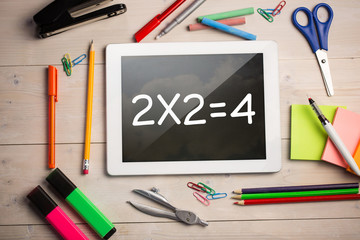 Composite image of digital tablet on students desk showing math equations