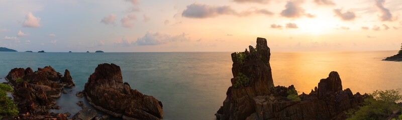 Large rocks and spiky filed in sea green waters and golden evening sky. Long Exposure Photography Technique .Chai Chet, Koh Chang, Trat, Thailand