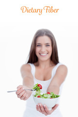 The word dietary fiber against delicious salad being eaten by a young woman