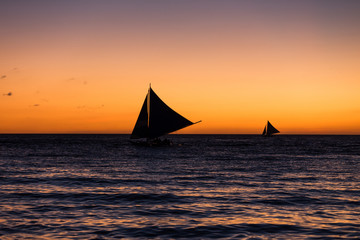 Fototapeta na wymiar Two outrigger sailboat on the horizon