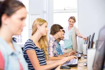 Fototapeta premium Computer teacher helping students