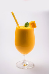 Mango Lassi or smoothie in big glass with mint leaf. Side angle  Isolated over colourful...