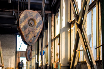 Metal lifting hook on the territory of an industrial building
