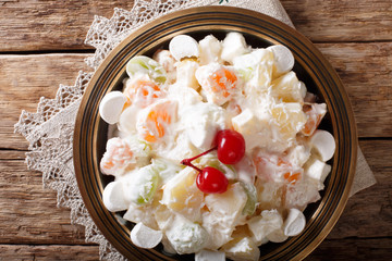 Light fruit salad Ambrosia with marshmallow and vanilla yogurt close-up. horizontal top view