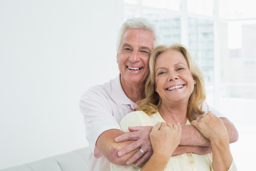 Happy senior man embracing woman from behind