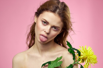 Fototapeta premium woman with a flower shows tongue