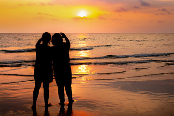 Silhouette couple on the beach sunset background