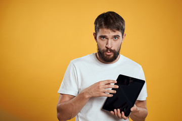man holding a tablet on a yellow background