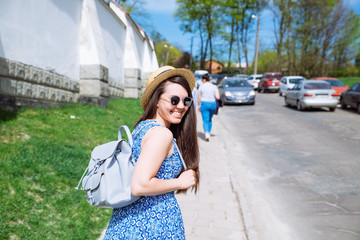 young pretty woman in blue dress and sunglasses walking in sunny day