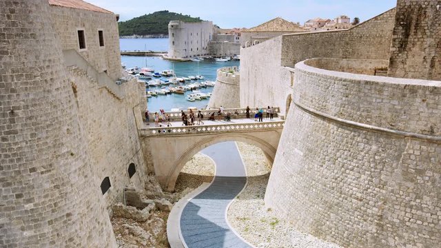 The sun is shinning on Dubrovnik&rsquo;s inner gate bridge connecting Fort Revelin to Ploce Gate, with the Old Harbour and the Adriatic Sea in the background/Dubrovnik, Croatia. Shot with RED Weapon Helium.