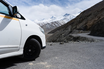 Close up side of car parking on the mountain road and Beautiful mountains snow capped ,Road to Pangong Lake in Leh, Ladakh, North India