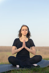Fototapeta na wymiar Girl in black meditates 