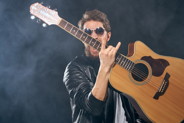 emotional guitarist with glasses and a leather jacket
