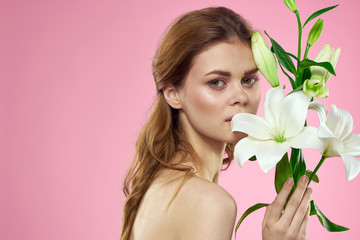 beautiful woman on a pink background and a white flower in the foreground