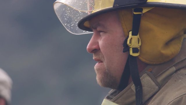 Close-up shot of a fireman as he surveys the scene and whistles