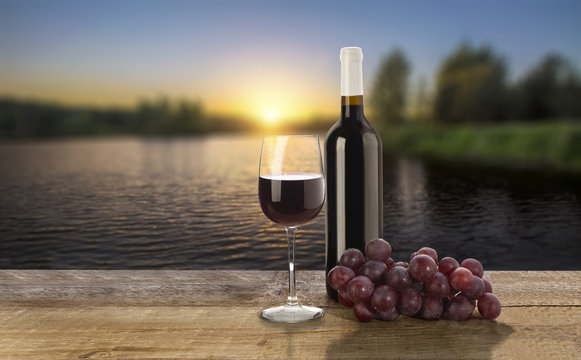 Red wine bottle,  wine glass and grape on sunset background