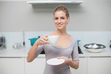 Cheerful gorgeous model looking at camera holding mug