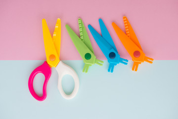 Minimal flat lay concept of colourful scissors with separate the blade for changing on the colorful background with copy space