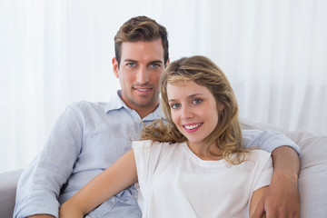 Loving young couple sitting on couch