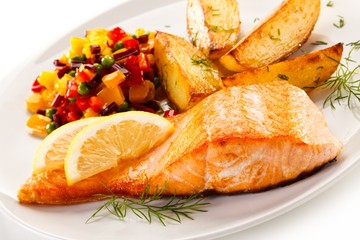 Fried salmon and vegetables on white background