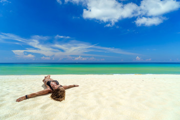 Fototapeta na wymiar woman sunbathing lying down on the tropical beach