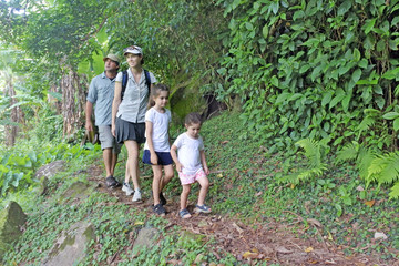 Naklejka na ściany i meble Family hiking the Cross Island Track in the rain forest of a tropical pacific island