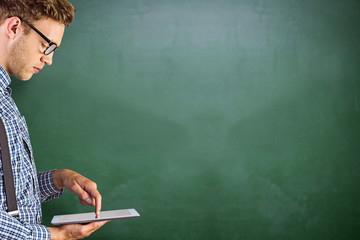 Geeky businessman using his tablet pc against green chalkboard