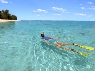 Young woman snorkelling  in a lagoon in Rarotonga Cook Islands