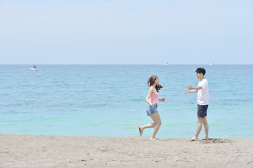 ビーチで恋人に駆け寄るカップル