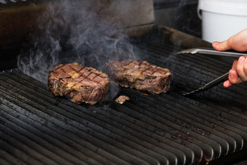 Prime beef steak being grilling on an open grill