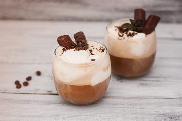 Iced Mocha Frappe Coffee with Whip Cream, Summer Drinking times. Coffee Beans. rustic textured Wooden Background. Mint Leaves