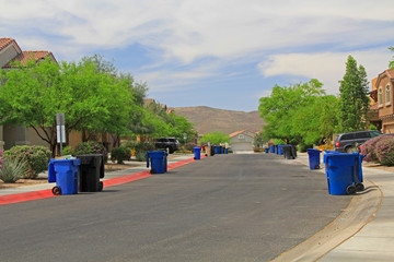 Blue trash cans line the street on trash day in a Tucson Neighborhood with blue sky copy space. © Linda J Photography