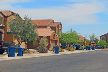 Blue trash cans line the street on trash day in a Tucson Neighborhood with blue sky copy space. © Linda J Photography