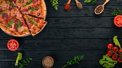Pizza with sausage salami and mozzarella. Top view. On a wooden background. Copy space.