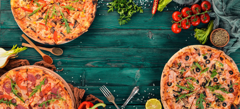Set pizza. Italian cuisine. Top view. On a wooden background. Copy space.