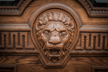 Big wooden head of lion on the front door