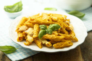 Pasta with creamy pumpkin sauce and fresh basil