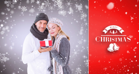 happy winter couple with gift against red vignette