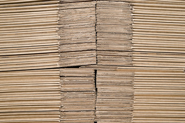 Texture of stacked on each other sheets of cardboard representing the unformed boxes for product packaging.