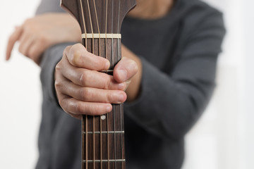 Woman's hands playing acoustic guitar.