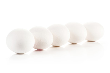Five white chicken eggs in row isolated on white background.