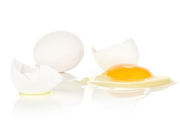 One cracked white chicken egg and one whole isolated on white background two pieces of shell and raw fresh yolk.