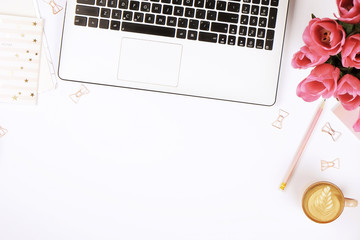 Feminine desktop close up, laptop computer keyboard, cup of coffee w/ latte art, pink flowers....