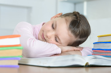 Cute schoolgirl sleeping on book