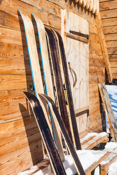 wide hunting skis near wall of wooden cottage