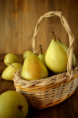 Little pears in a wicker basket on wooden background
