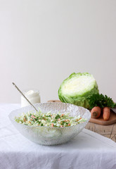 Fresh coleslaw salad in bowl and ingredients for salad. Rustic style.