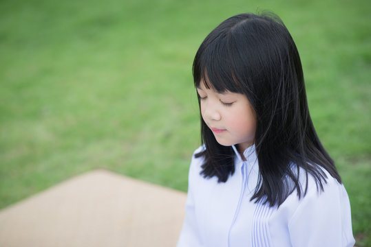 Asian girl wearing white dress meditating