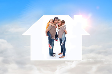 Parents giving children piggyback ride against blue sky with white clouds