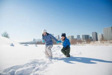 Fototapeta na wymiar Cute Asian children playing on snow togethe